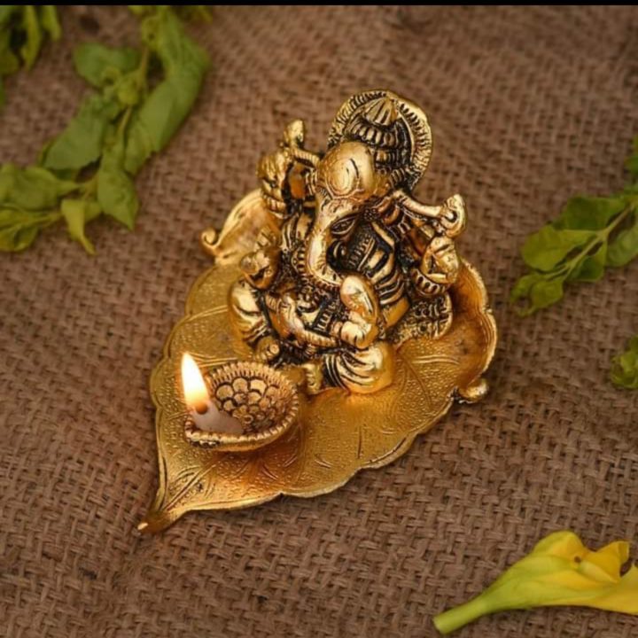 Ganesha idol on leaf with Diya